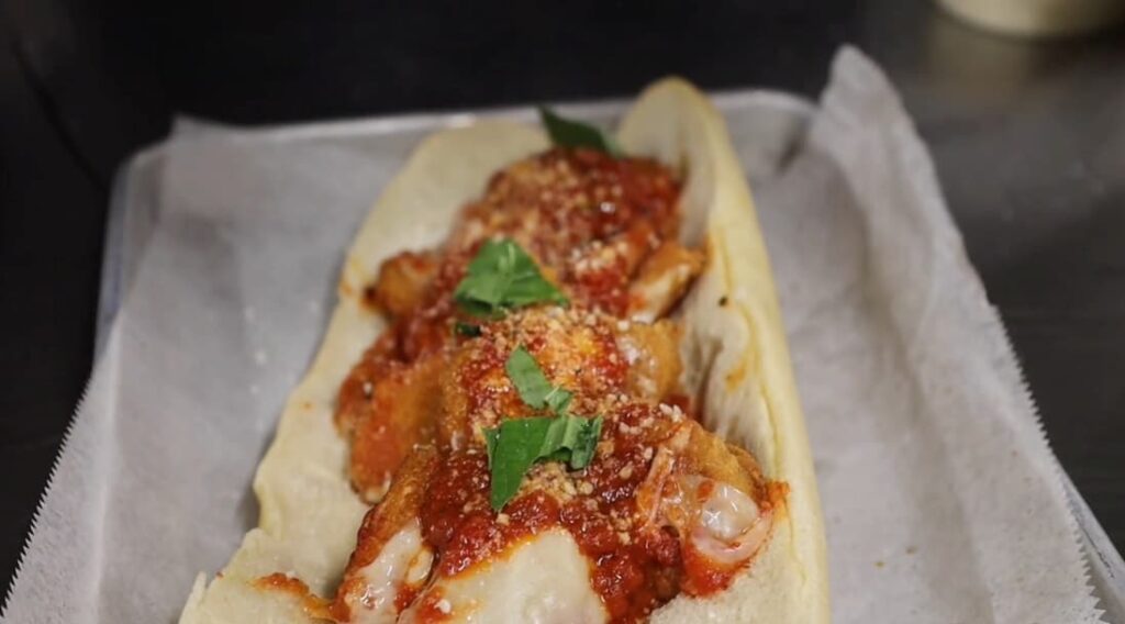 A sub roll stuffed with 20 chicken mcnuggets from mcdonald's, topped with our marinara sauce, parmesan and basil leaves