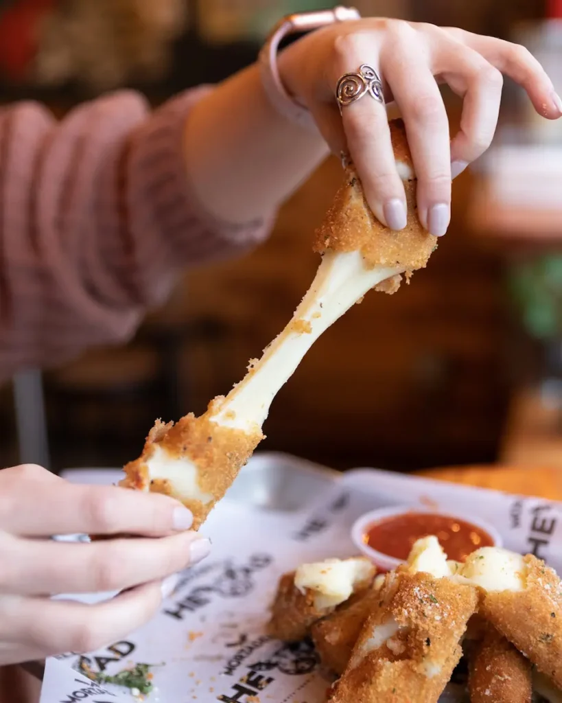 an air fried mozzarella sticks in the middle of an epic cheese pull