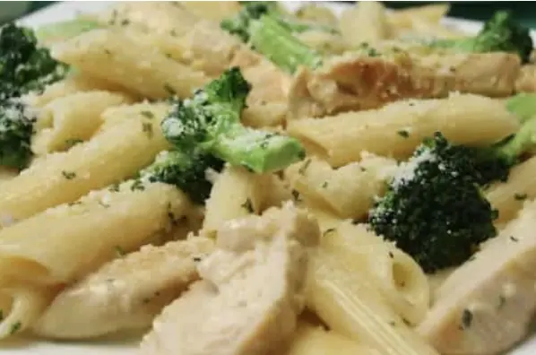 a close image of penne pasta with chicken and broccoli