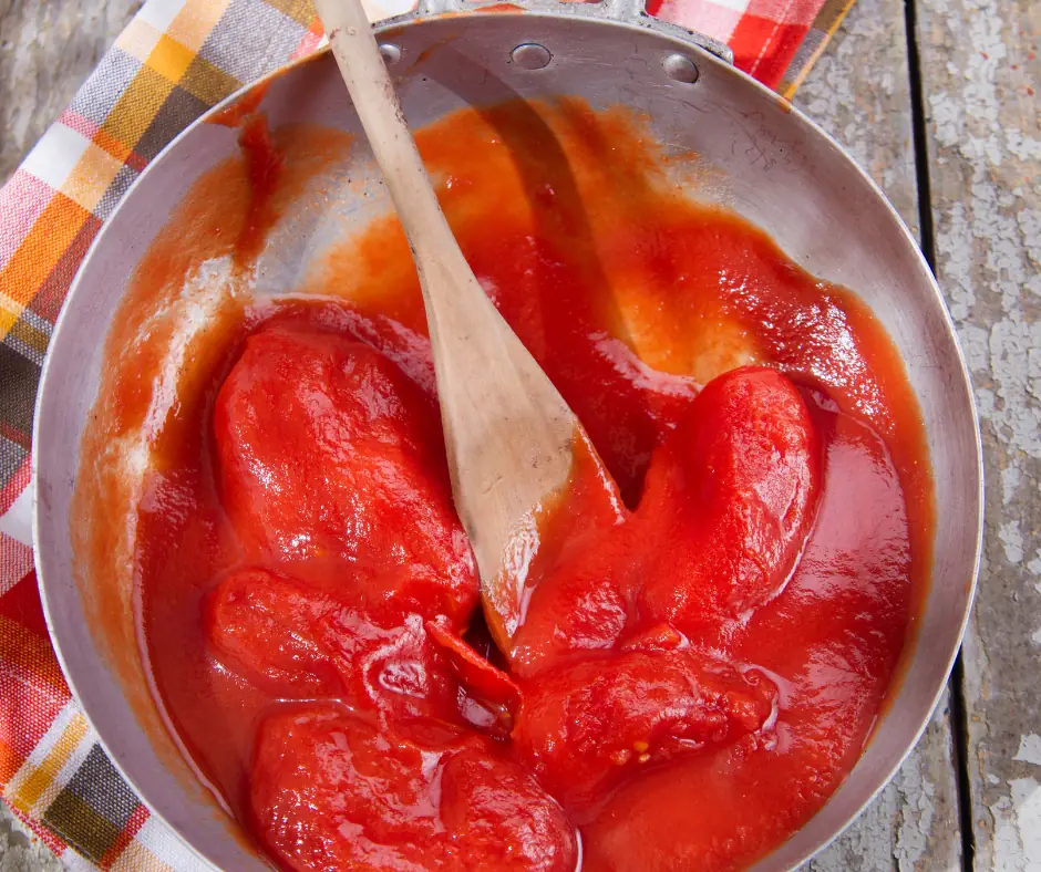 peeled tomatoes cooking in a saucepan