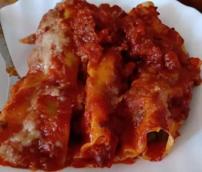 some baked cannelloni filled with ricotta and dressed in meat & tomato sauce