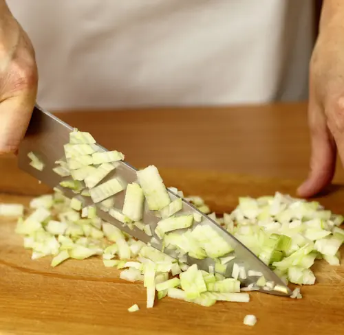 a western chef's knife cutting vegetables