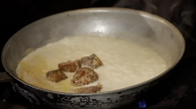 meat simmering in alfredo sauce
