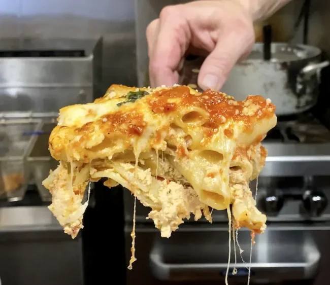 detail of ziti pasta inside a piece of baked ziti