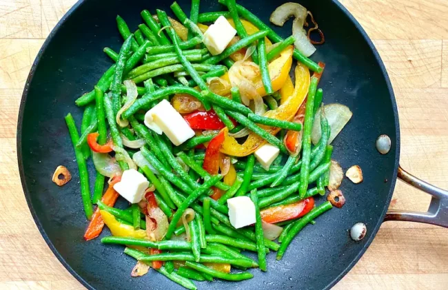 adding butter to sauteed haricot verts