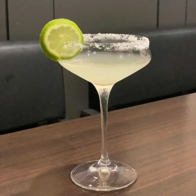 our first attempt: detail of a long stem glass filled with Italian margarita and garnished with a wedge of lime