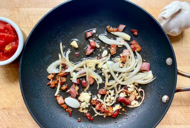 adding garlic and onions to the saucepan