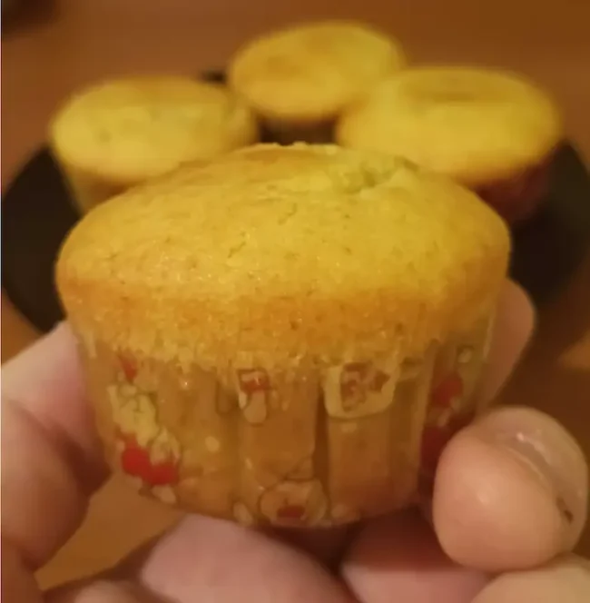 a hand holding a light greek yogurt muffin made for Christmas