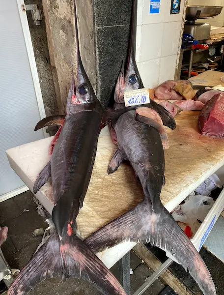 two swordfishes on sale at a seafood market