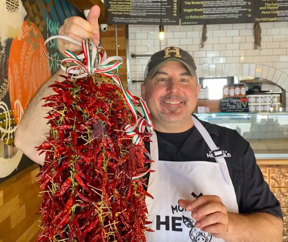 a picture of Chuck happily holding a bunch of calabrian chili peppers