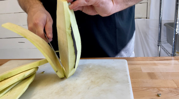 slicing an eggplant to make eggplant parmigiana