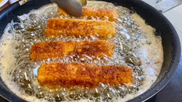 Breaded mozzarella sticks ready for frying