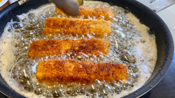 mozzarella sticks frying in hot olive oil