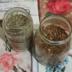 2 jars of homemade Italian seasoning: one made with basic herbs, and one spiced up with chili pepper flakes and seeds