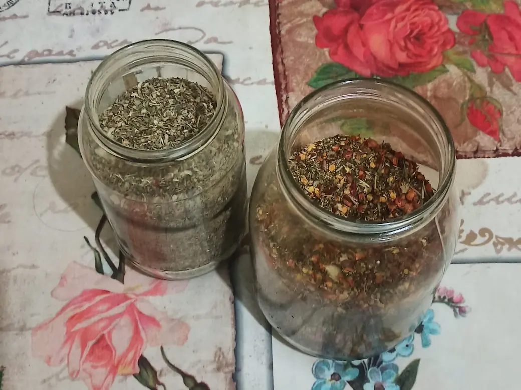2 jars of homemade Italian seasoning: one made with basic herbs, and one spiced up with chili pepper flakes and seeds