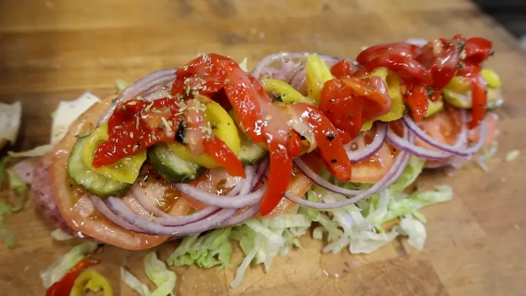 how to make an italian sub sandwich final step: tomatoes and peppers