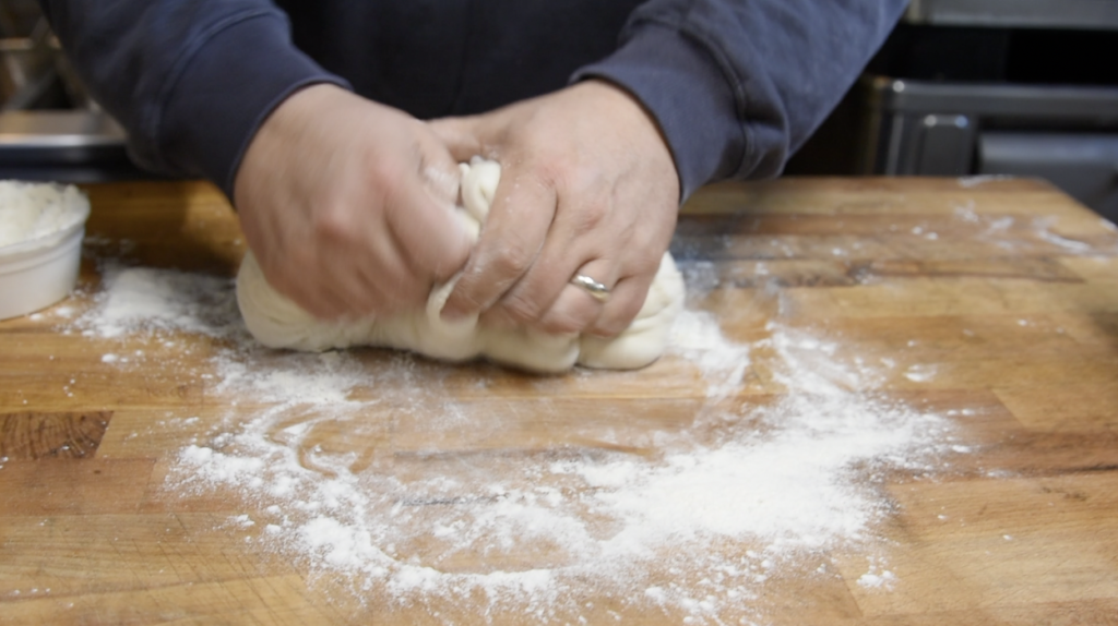 Fold the dough ball in half and join the edges