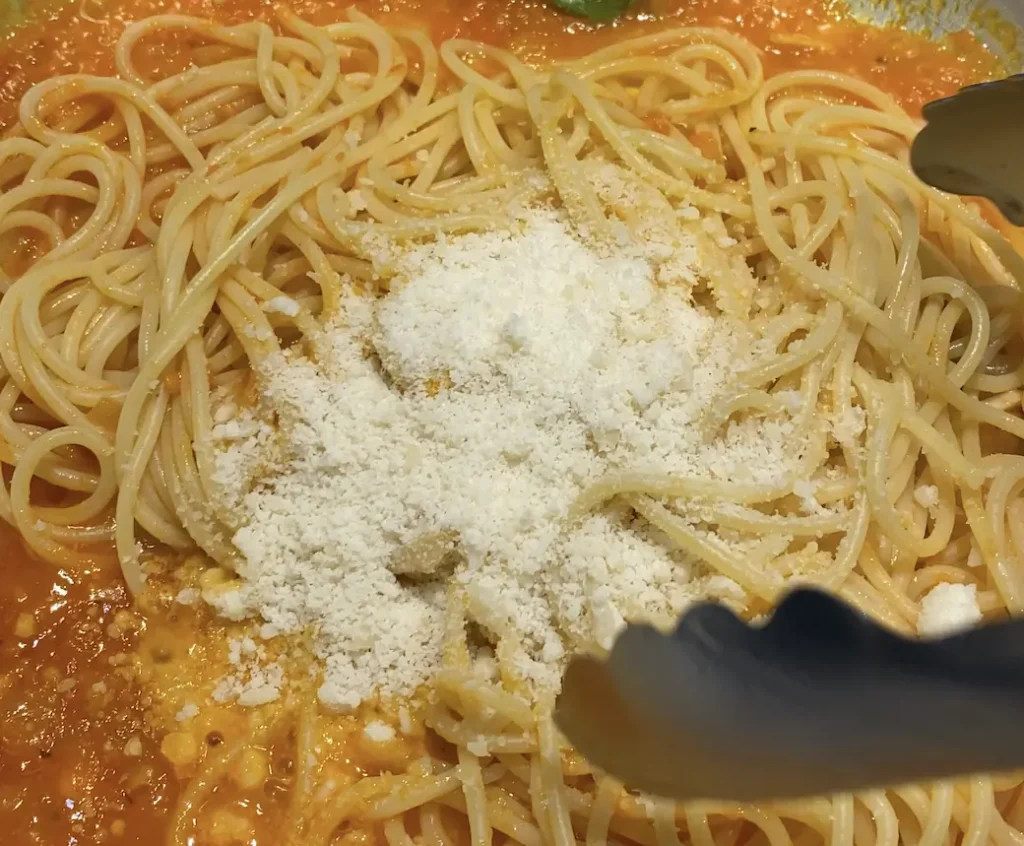 a bowl of spaghetti with tomato sauce and parmesan