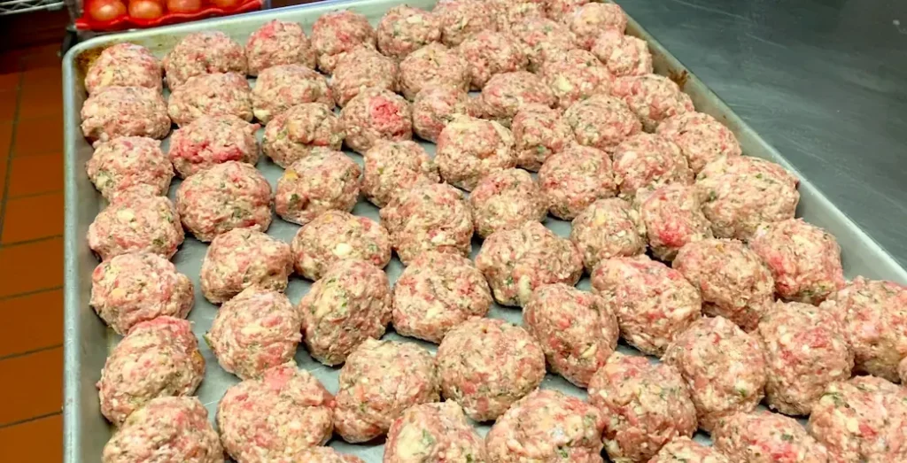 a picture of many many meatballs ready to be baked and served