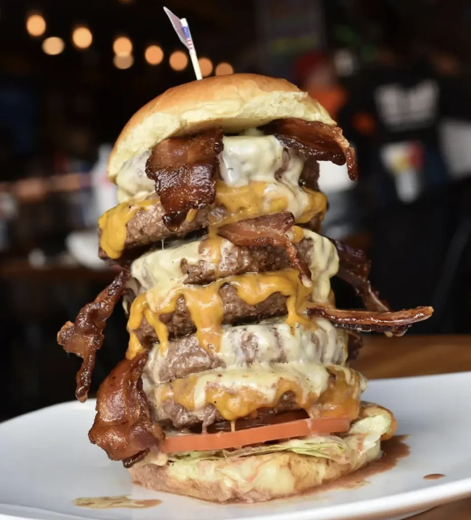 A smashed burger with 4 pieces of meat and lots of sauces.