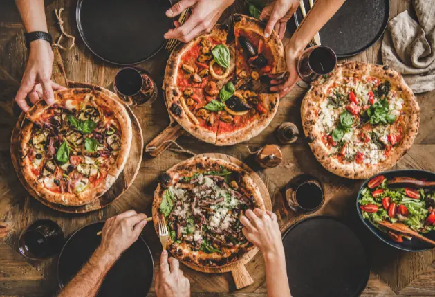 4 round pizzas at a table