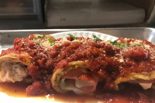 a tray of eggplant involtini full of seasoned ricotta