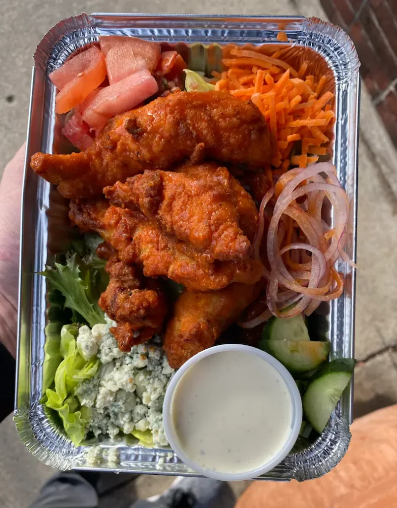 a portion of chicken wings served with vegetables