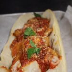 A sub roll stuffed with 20 chicken mcnuggets from mcdonald's, topped with our marinara sauce, parmesan and basil leaves