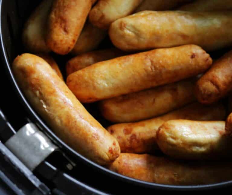 a bunch of sausages in an air fryer basket