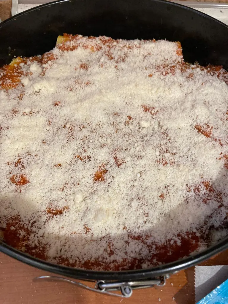 the same cannelloni in the same baking dish, but with an extra layer of tomato sauce and grated parmesan