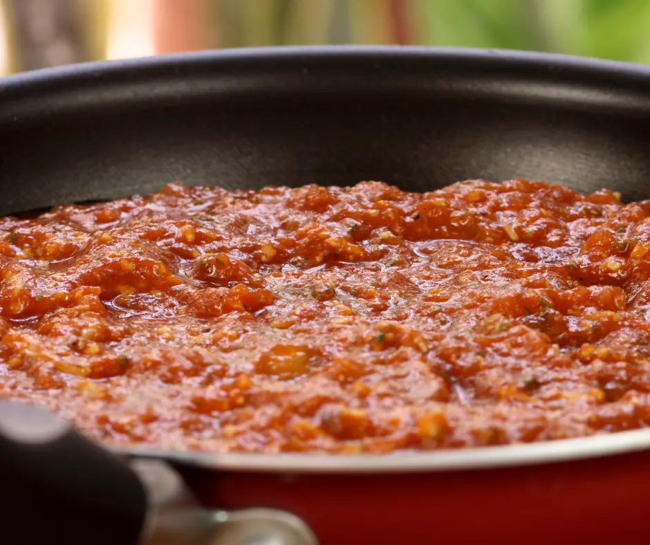 a thick tomato sauce heating in a saucepan