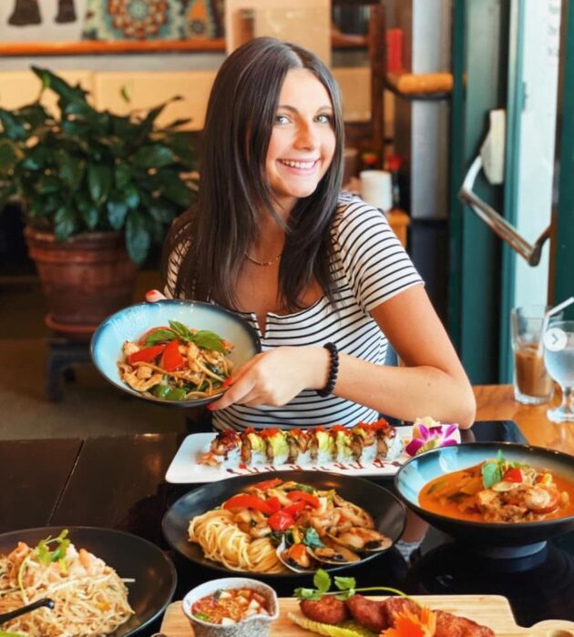 food influencer jordansplate holding a plate at a restaurant table