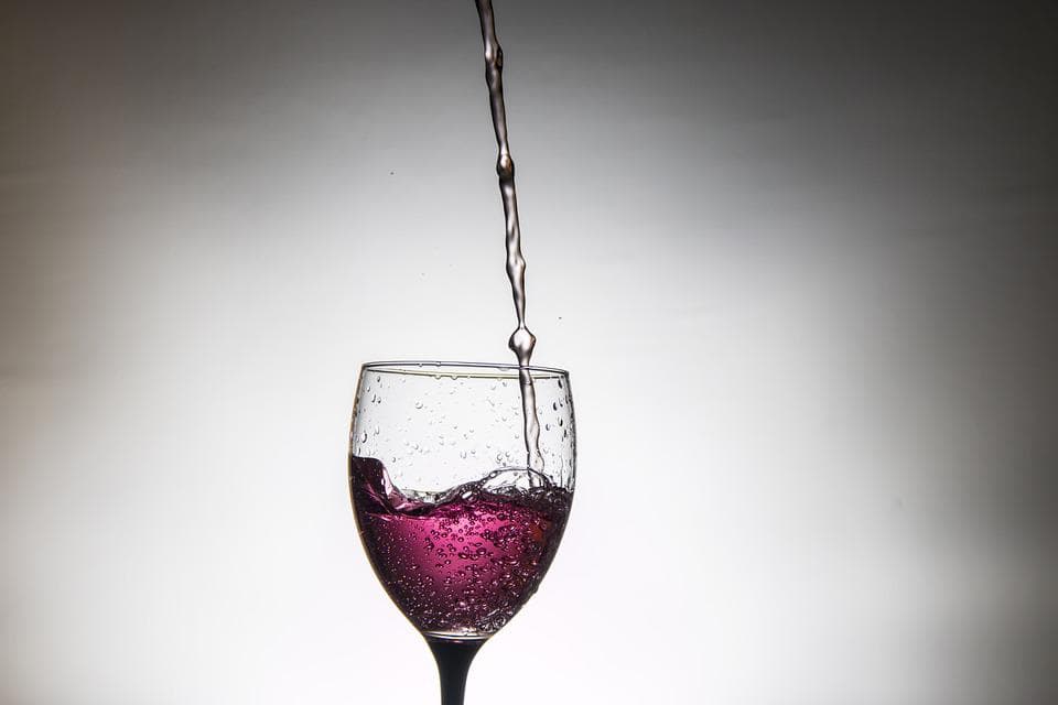 a glass of rosee wine being filled
