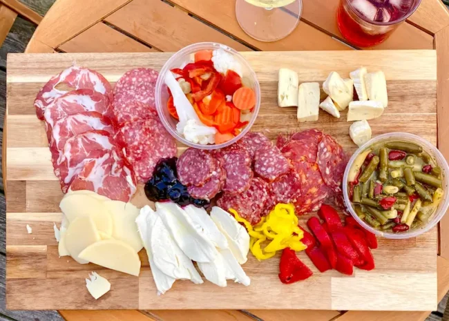 an antipasto platter full of meat, cheese, and vegetables