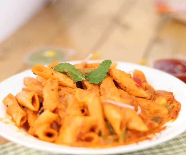 a plate full of penne pasta dressed with Italian pink sauce