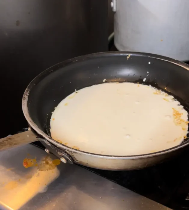 pesto cream sauce simmering in a sauce pan