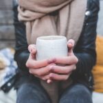 hands holding a cup of herbal tea against colds and flu