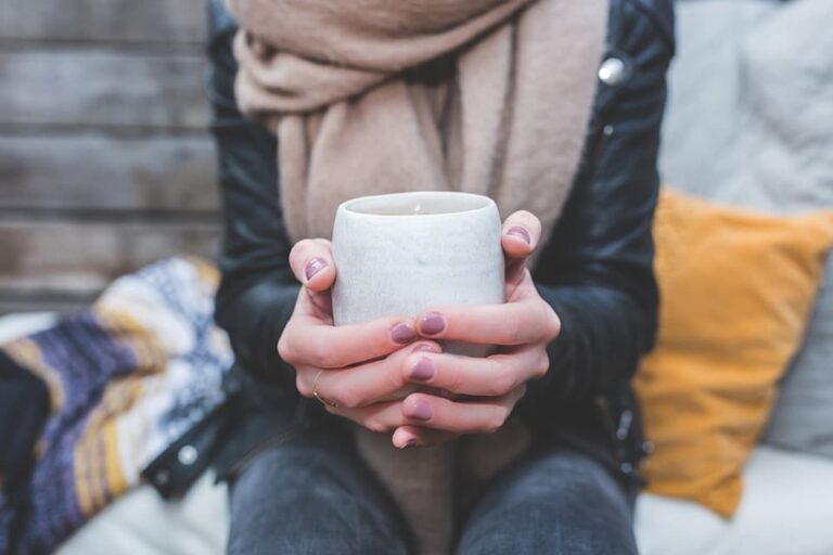 hands holding a cup of herbal tea against colds and flu