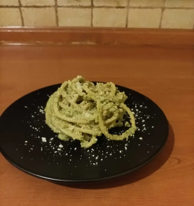 the finished pasta on a black plate with a dusting of parmesan cheese