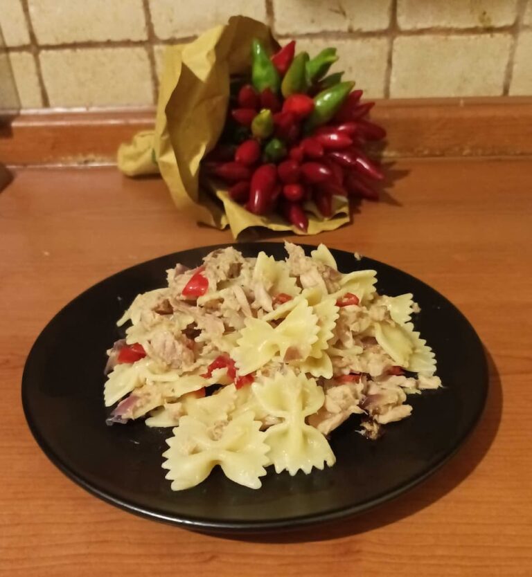 a plate of spicy tuna pasta next to a bunch of Calabrian chili peppers