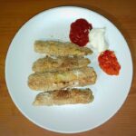 baked zucchini fries on a plate with sauces