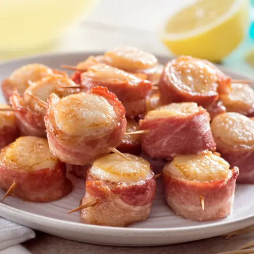 bacon wrapped scallops on an appetizer dish