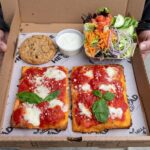 a box with pizza made with low sodium marinara, a salad, and a cookie