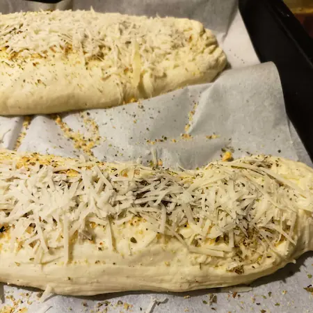 adding herbs and cheese to the bread rolls