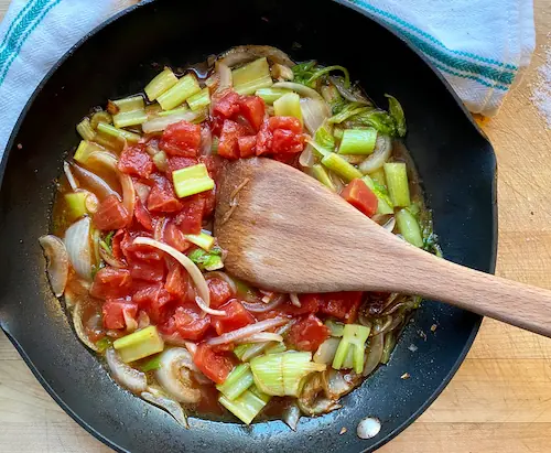 adding tomatoes to the sauteed celery and onions