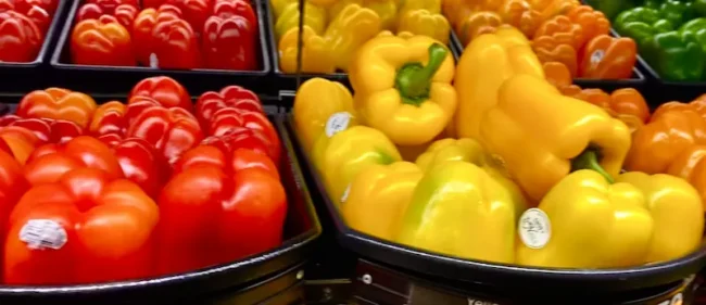yellow, green and red bell peppers in store boxes