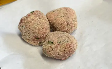 homemade meatballs rolled in breadcrumbs for frying