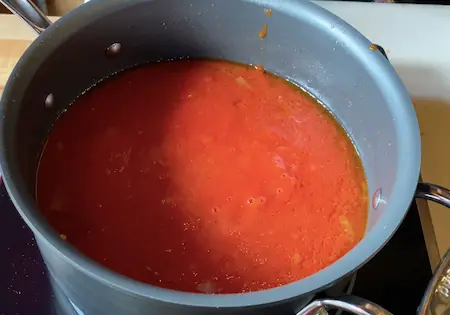 meatballs simmering in sauce on the stove