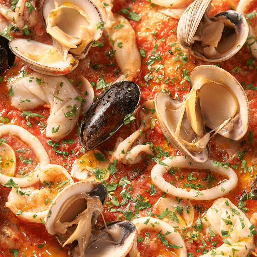 Close-up of seafood in tomato sauce with herbs