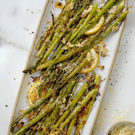 Roasted asparagus with lemon slices on a serving plate